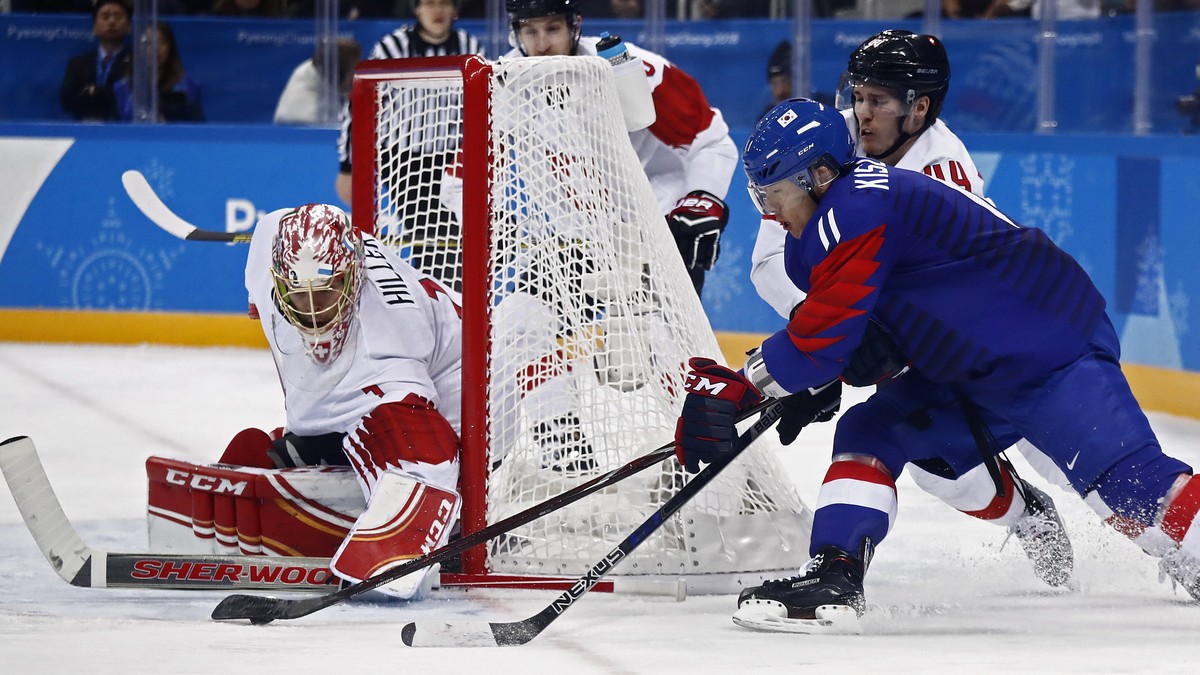 epa06535331 Jonas Hiller (L) of Switzerland blocks a shot against Kisung Kim (R) of Republic of Korea during the men's preliminary round inside the Gangneung Hockey Centre at the PyeongChang Wint ...