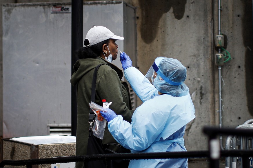 A patient is given a COVID-19 test by a medical worker outside Brooklyn Hospital Center, Sunday, March 29, 2020, in Brooklyn borough of New York. The new coronavirus causes mild or moderate symptoms f ...