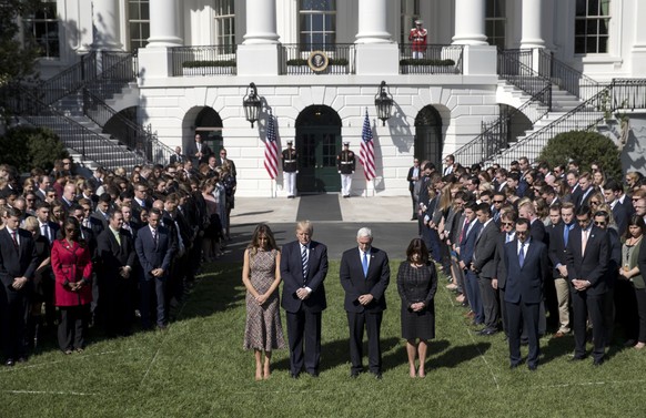 President Donald Trump and first lady Melania Trump stand with Vice President Mike Pence, his wife Karen, and members of the White House staff during a moment of silence to remember the victims of the ...