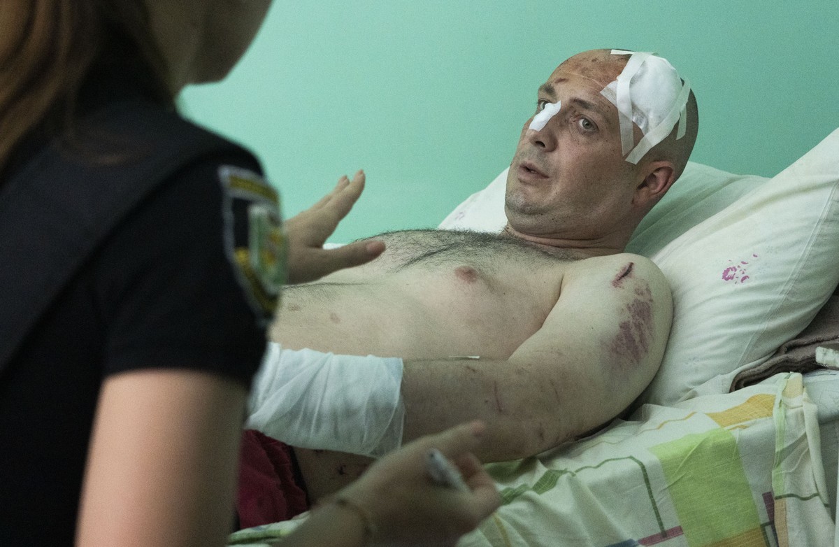 A police officer writes a report as a man wounded by the Russian deadly rocket attack at a shopping centre tells her about the attack in a city hospital in Kremenchuk in Poltava region, Ukraine, Tuesd ...
