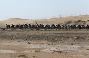 Statt Sonnenblumen für einmal karge Wüste am Strassenrand eines Profirennens: Das Feld unterwegs in den Arabischen Emiraten.