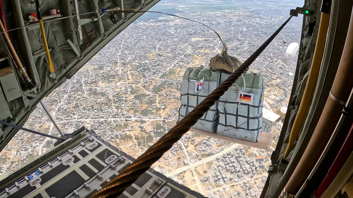 epa11224217 A handout photo made available by German Armed Forces shows a C-130 of the bi-national German-French squadron 'Rhein/Rhin' drops relief supplies over the Gaza Strip, 16 March 202 ...