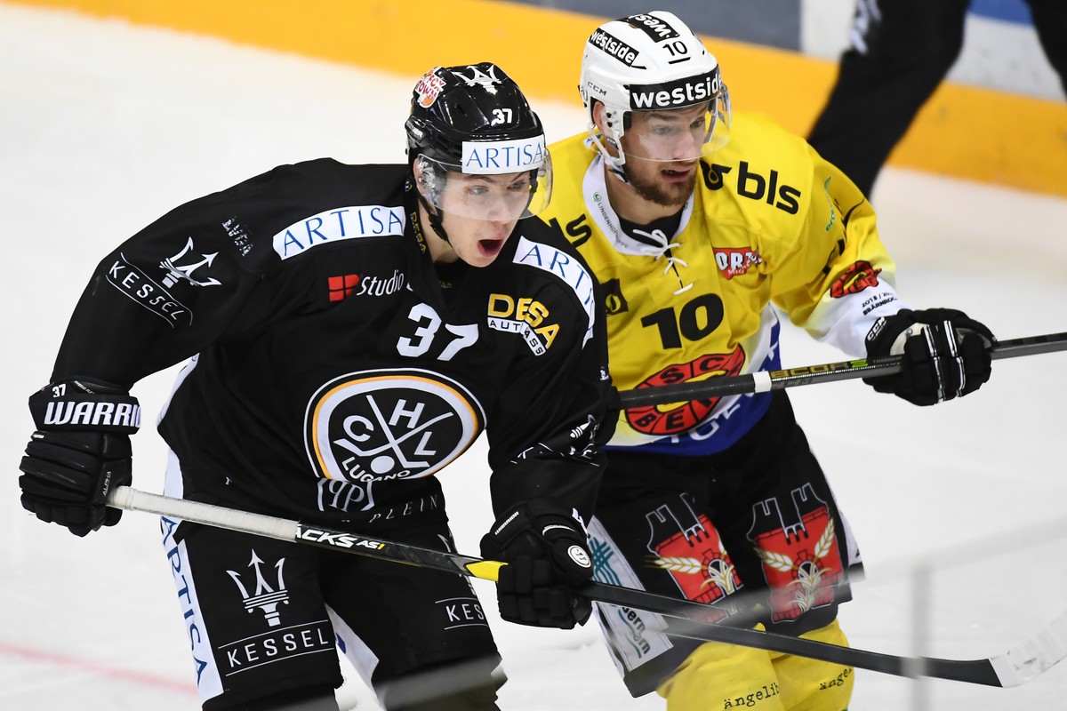 Lugano's player Elia Riva, left, fights for the puck with Bern's player Tristan Scherwey, right, during the preliminary round game of National League Swiss Championship 2018/19 between HC Lu ...