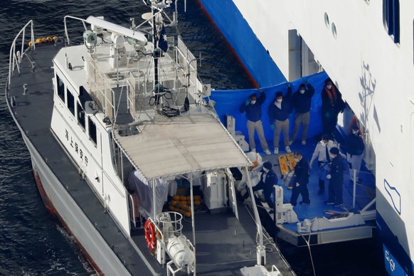 Japan Coast Guard&#039;s patrol boat, left, is brought alongside the cruise ship Diamond Princess to take passengers tested positive for coronavirus to hospitals off Yokohama, south of Tokyo, Wednesda ...