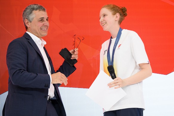 Swiss Federal Councillor Ignazio Cassis, left, speaks with Audrey Gogniat of Switzerland bronze medal winner in the women&#039;s 10m air rifle competition, at the reception in the maison suisse at the ...