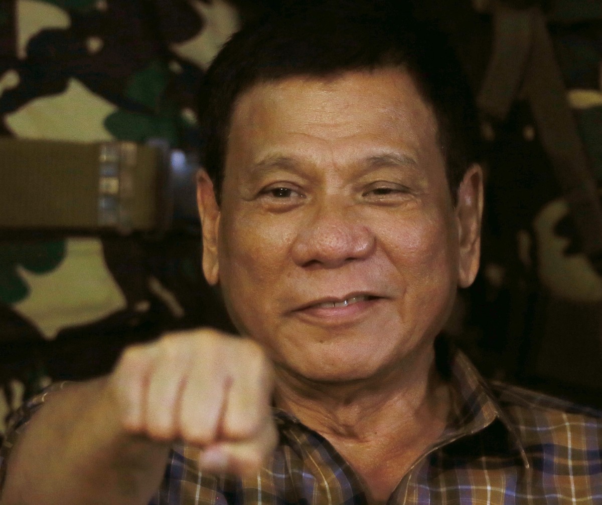 FILE - In this Aug. 25, 2016, file photo, Philippine President Rodrigo Duterte gestures with a fist bump during his visit to the Philippine Army's Camp Mateo Capinpin at Tanay township, Rizal pro ...