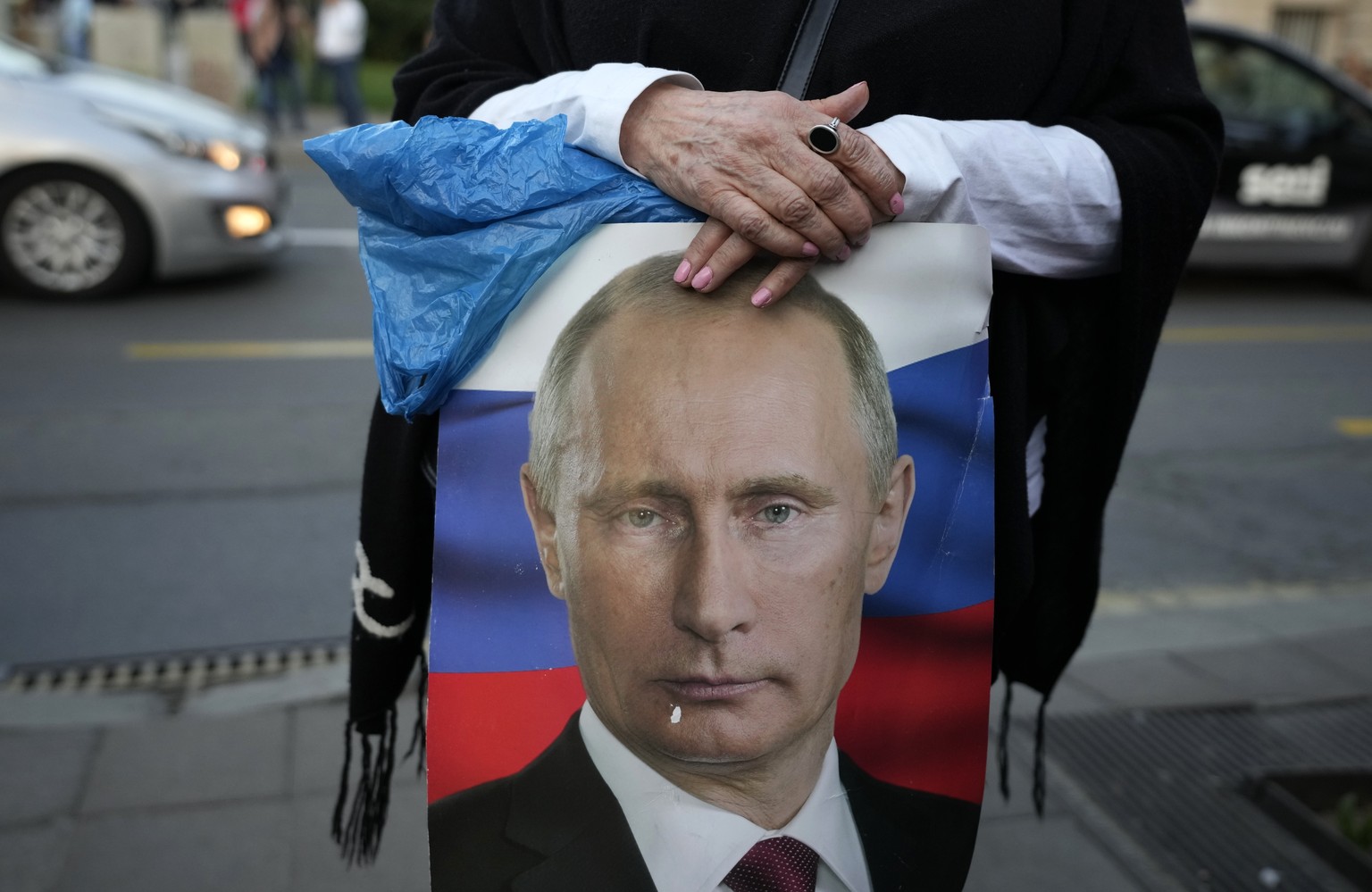 A woman holds a picture of Russian President Vladimir Putin during a protest against the Serbian authorities for voting to suspend Russia&#039;s membership in the UN Human Rights Council in Belgrade,  ...