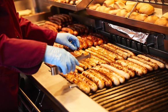 epa05722065 A salesman grills sausages at a Moe-Grill store in a shopping street in Hamburg, Germany, 16 January 2017. Moenke-Grill is a family business. It is operated in the second generation for 35 ...