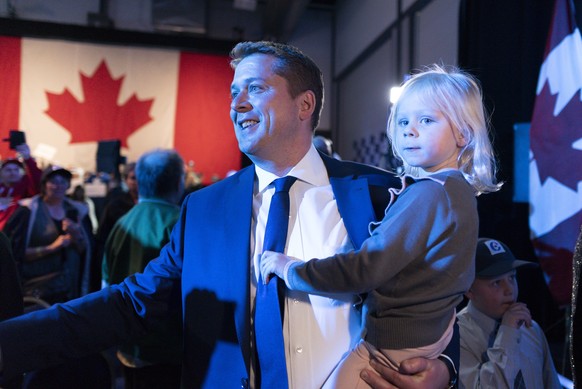 Andrew Scheer holds his daughter Mary while making his way to the stage at Conservative Party HQ at Evraz Place on Election Day in Regina on Monday Oct. 21, 2019. (Michael Bell/The Canadian Press via  ...