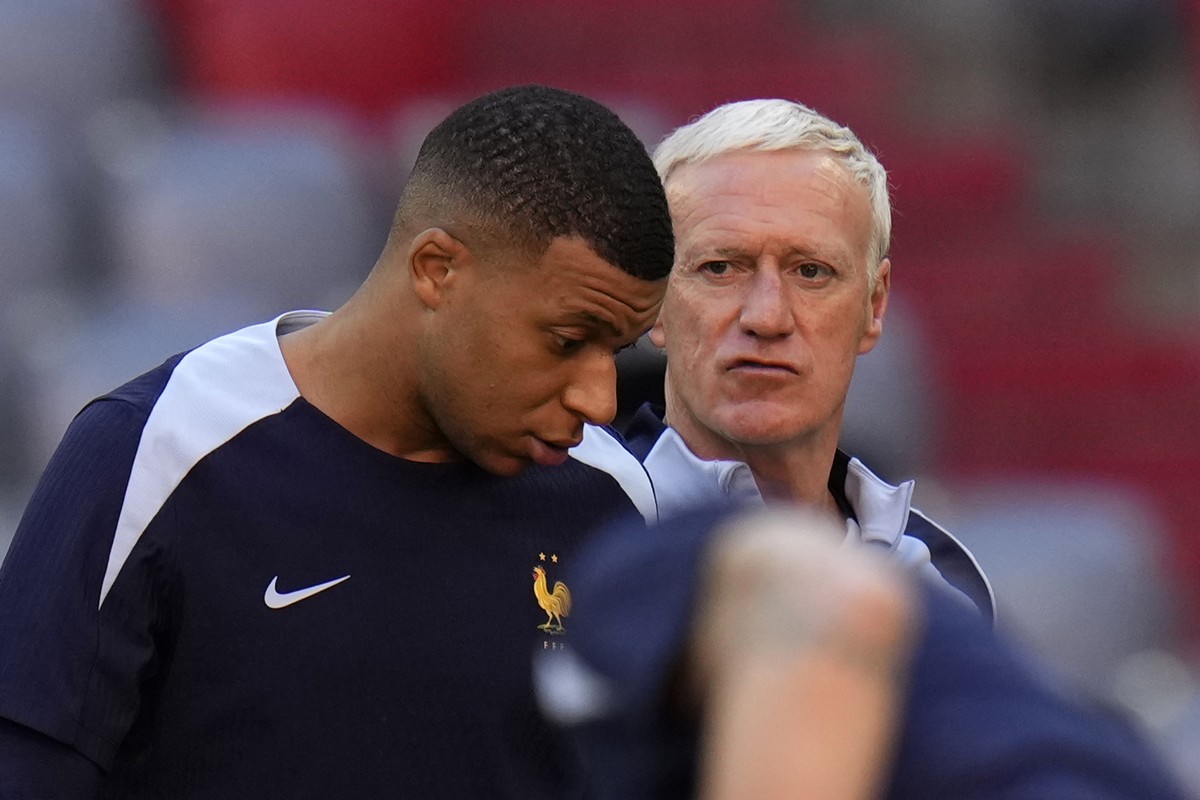 France's Kylian Mbappe, left, gestures as he speaks with his head coach Didier Deschamps during a training session in Munich, Germany, Monday, July 8, 2024. France will play against Spain during  ...