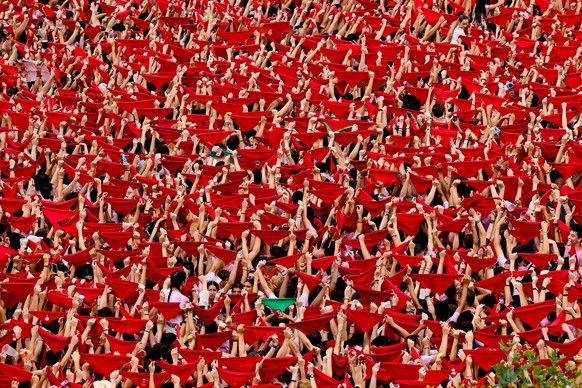 epa10729233 Thousands of people filling Castillo Square raise their red scarves to celebrate the start of the 2023 Sanfermines in Pamplona, ​​​​​​Northern Spain, July 06, 2023.  Sanfermines runs from…