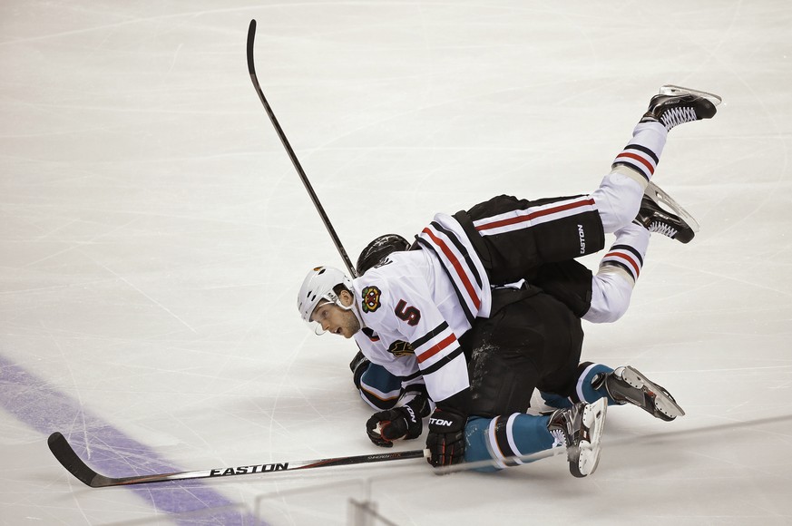 Chicago Blackhawks defenseman David Rundblad (5) goes tumbling over San Jose Sharks left wing Tye McGinn during the first period of an NHL hockey game Saturday, Jan. 31, 2015, in San Jose, Calif. (AP  ...