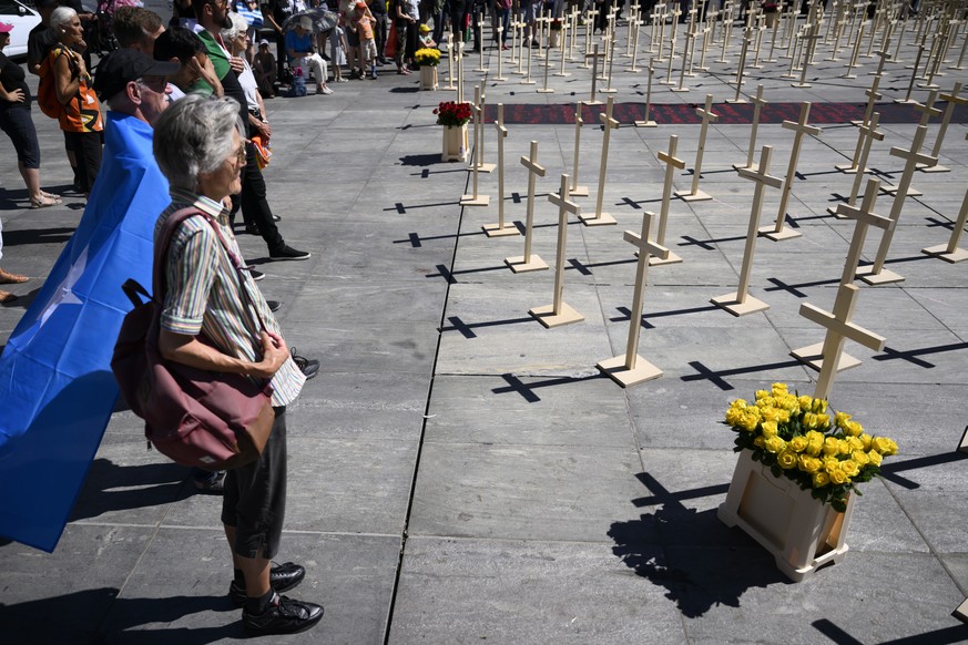 Personen vor die Holzkreuze waeherend die Kundgebung der Evangelischen Allianz gegen Christenverfolgung, am Samstag, 9. Juli 2022 auf dem Bundesplatz, in Bern. (KEYSTONE/Anthony Anex)