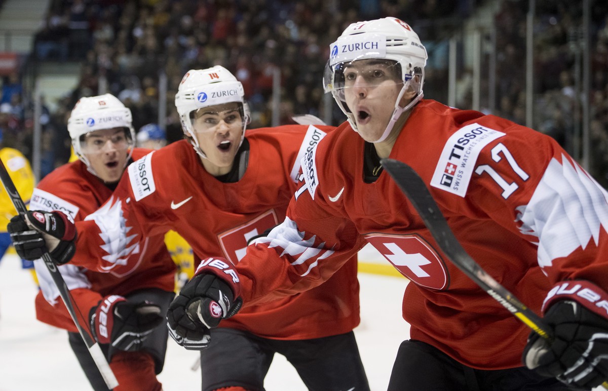 Switzerland's Luca Wyss, right, celebrates his goal past Sweden with teammates Sandro Schmid and Matthew Verboon during the second period of a world junior hockey championships game in Victoria,  ...