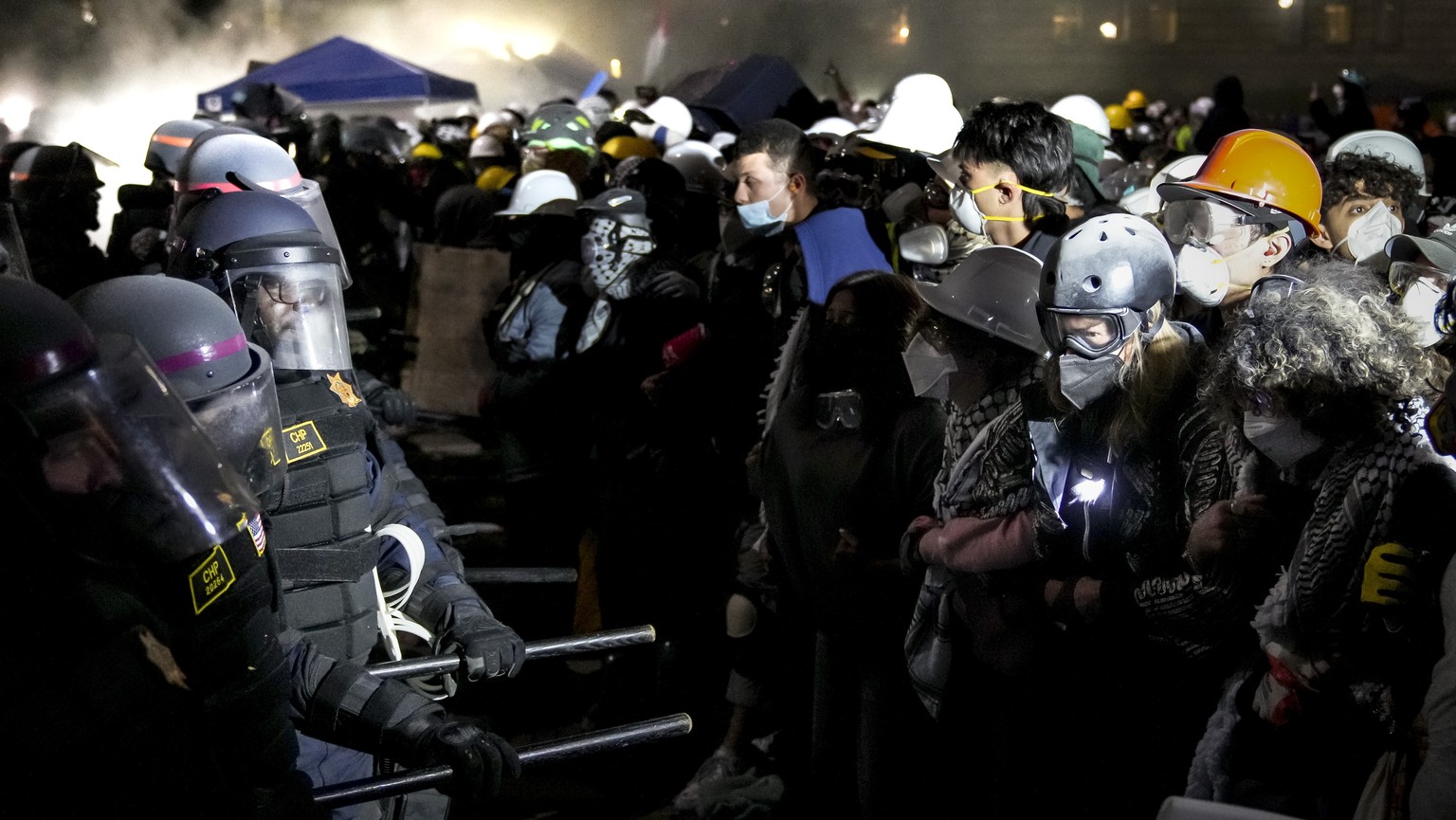 epa11314340 Police officers confront demonstrators gathered at the ongoing encampment of pro-Palestinian protesters on the campus of University of California Los Angeles (UCLA) in Los Angeles, Califor ...