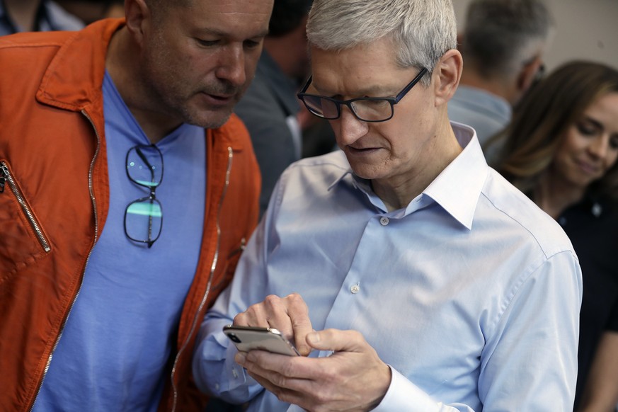 Apple CEO Tim Cook, right, and Jonathan Ive, Chief Design Officer shows the new iPhone X in the showroom after the new product announcement at the Steve Jobs Theater on the new Apple campus on Tuesday ...