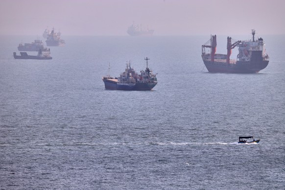 A small boat sails past cargo ships and other commercial vessels anchored in the Strait of Hormuz off Bandar Abbas, Iran, Wednesday, Aug. 5, 2026. (Amirhosein Khorgooi/ISNA via AP)
Iran War Strait of  ...