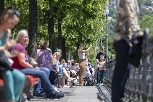 Spring tourism arrives in Ticino, on the shores of Lake Ceresio, several tourists sunbathe and stroll in Lugano, Switzerland, Friday 30 May 2025. (KEYSTONE/Ti-Press/Pablo Gianinazzi)