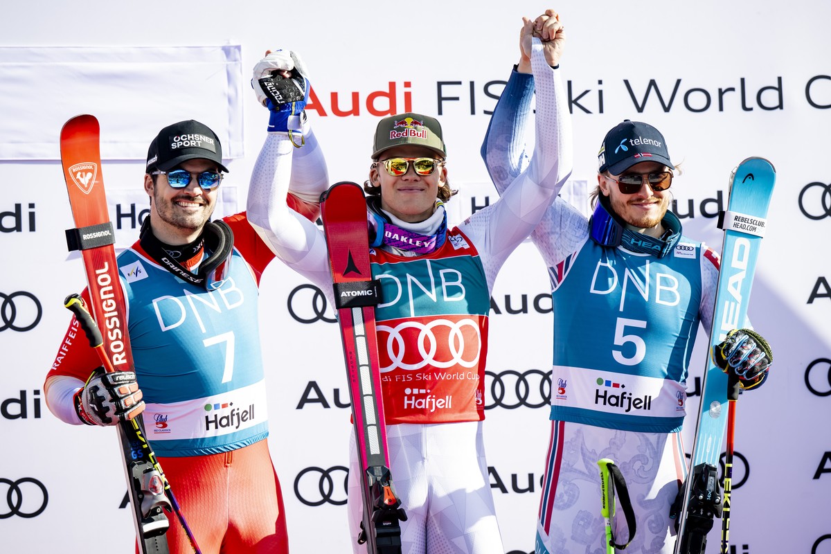 Second placed Loic Meillard of Switzerland, left, winner Lucas Pinheiro Braathen of Brazil, center, and third placed Atle Lie McGrath of Norway, right, celebrate during the podium ceremony of the men& ...
