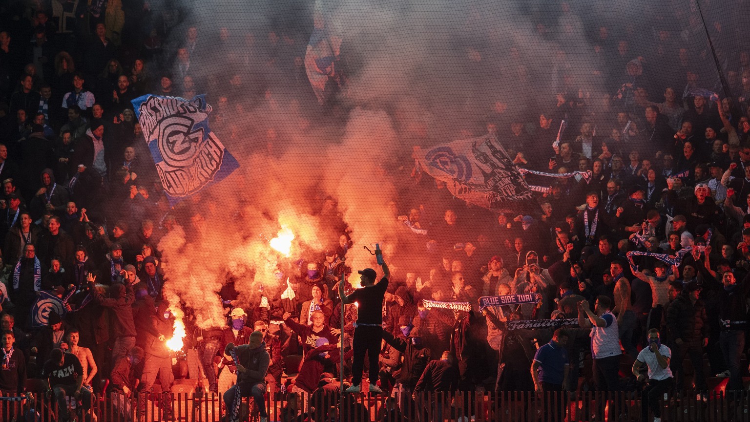 Die Grasshopper Fans zuenden Pyros im Fussball Meisterschaftsspiel der Super League zwischen dem Grasshopper Club und dem FC Zuerich im Letzigrund, am Samstag, 23. Oktober 2021 in Zuerich. (KEYSTONE/E ...