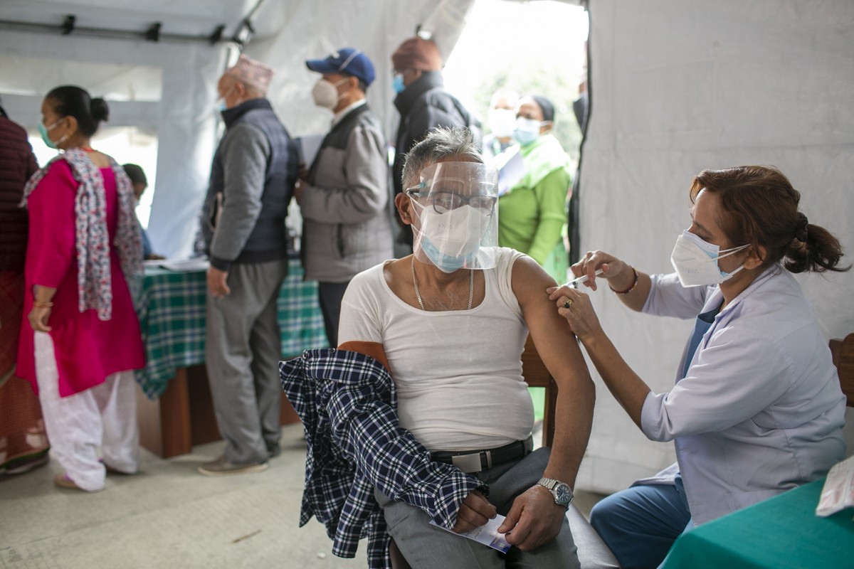 An elderly Nepalese man receives a dose of Covishield COVID-19 vaccine in Kathmandu, Nepal, Sunday, March 7, 2021. Nepal's Prime Minister Khadga Prasad Oli took the COVID-19 vaccine Sunday to sta ...