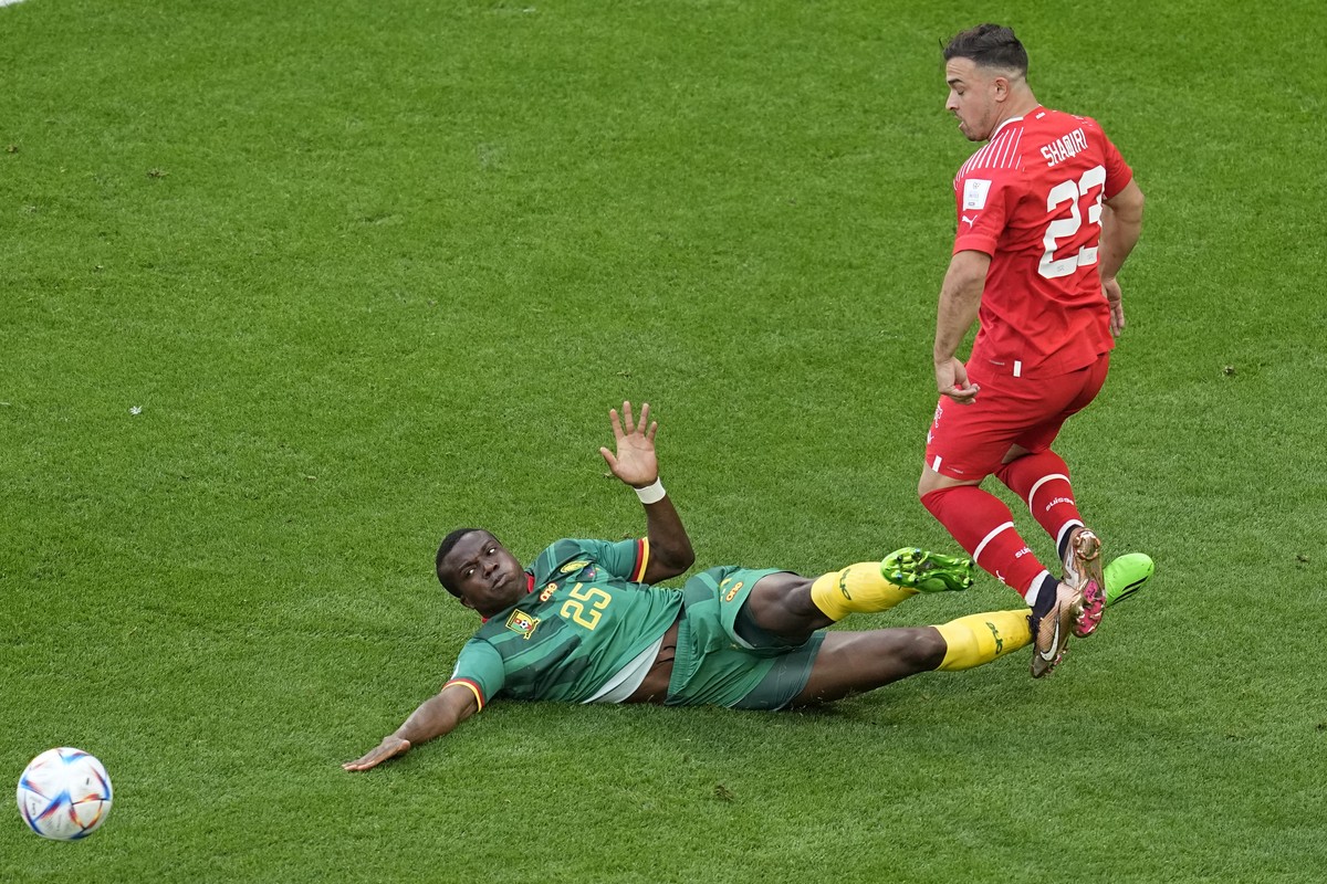 Switzerland's Xherdan Shaqiri is tackled by Cameroon's Tolo Nouhou during the World Cup group G soccer match between Switzerland and Cameroon, at the Al Janoub Stadium in Al Wakrah, Qatar, T ...
