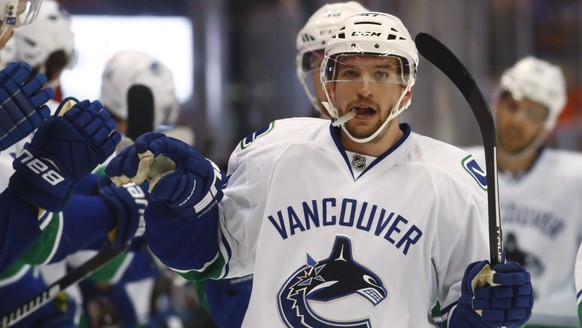 Vancouver Canucks left wing Sven Baertschi, of the Czech Republic, is congratulated as he passes the team box after scoring the go-ahead goal against the Colorado Avalanche during the third period of  ...