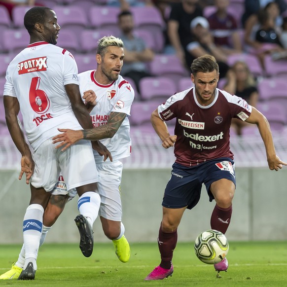 Le joueur de Servette Alex Schalk, droite, lutte pour le ballon contre deux joueurs de Sion, Behrami Valon, centre, Christian Zock, gauche, lors de la rencontre de football de Super League entre le Se ...