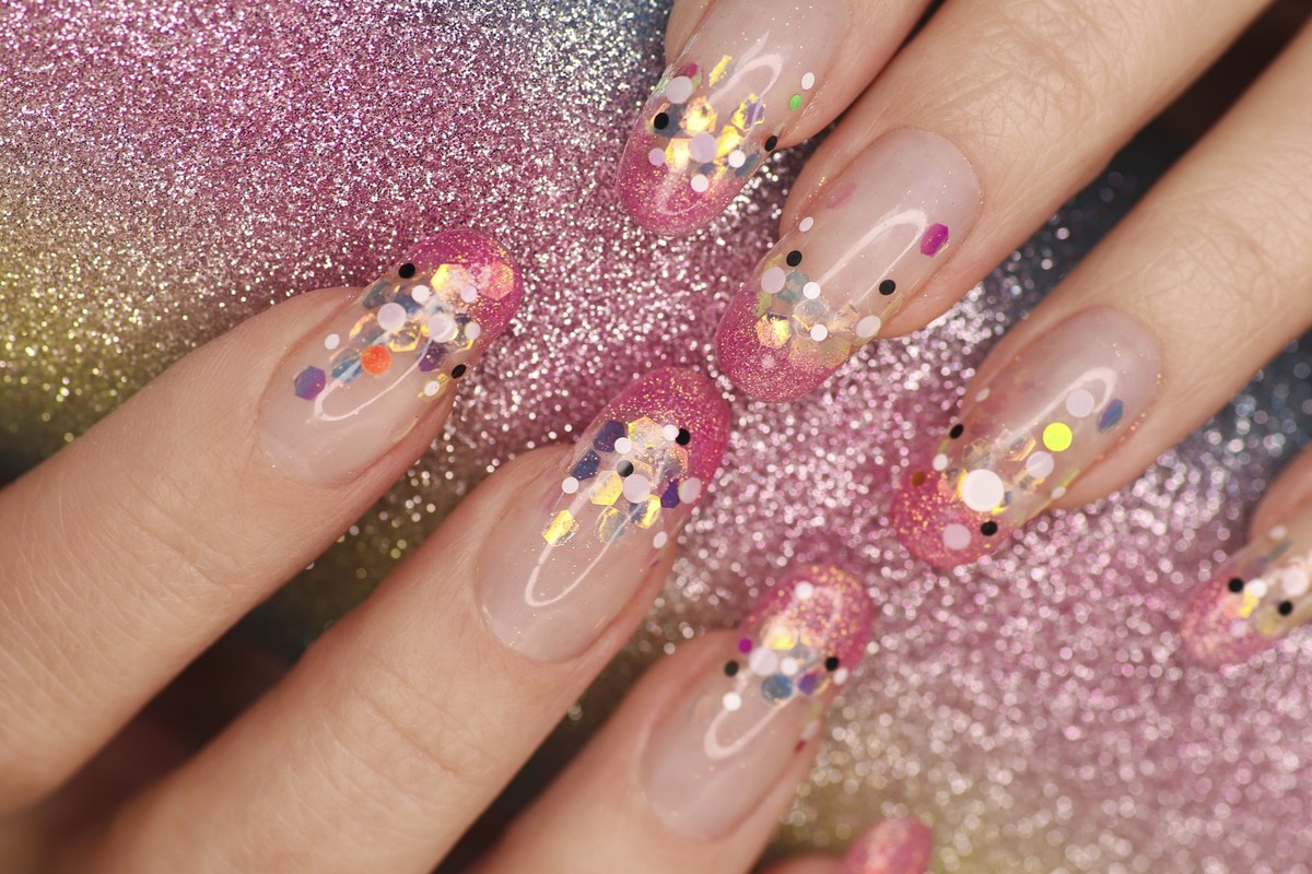 Fashionable aquarium French manicure on long rounded nails with sequins of different sizes. Gelnägel gel nails