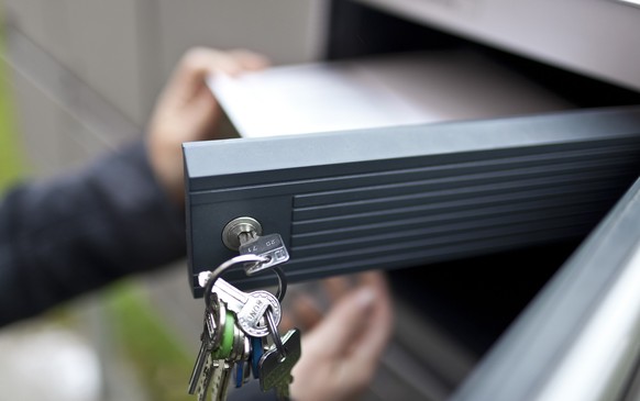 A woman gets her postal vote forms out of her letterbox on the occasion of the second tour of the election for the canton of Zurich's seat in the federal Council of States, pictured on November 2 ...