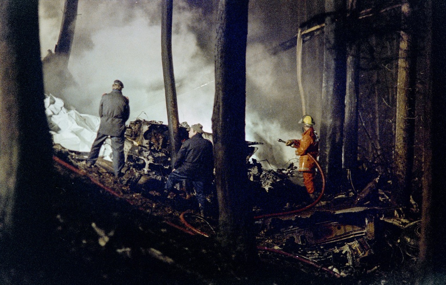 Police officers and fire fighters pictured during rescue work on Stadlerberg in the Canton of Zurich, Switzerland, where the Alitalia airplane crashed, pictured on November 14, 1990. All 46 passengers ...