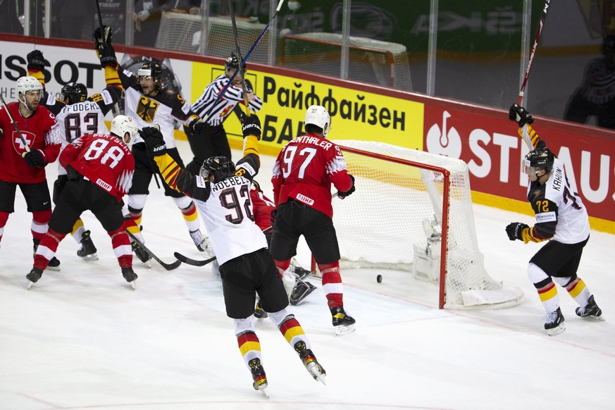 epa09245383 Players of Germany (white) celebrate their 2-2 equalizer during the IIHF Ice Hockey World Championship 2021 quarter final game between Switzerland and Germany at the Olympic Sports Centre  ...