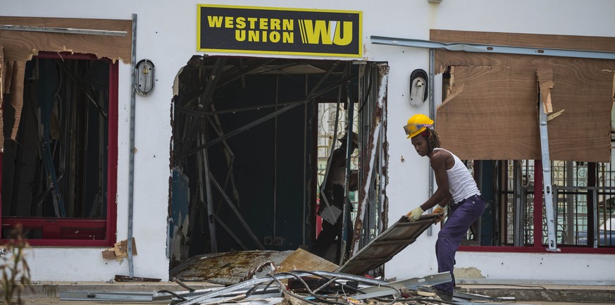 A worker clears out the debris of a Western Union office after the passing of Hurricane Irma, in Havana, Cuba, Tuesday, Sept. 12, 2017. Cuban state media reported 10 deaths despite the country&#039;s  ...