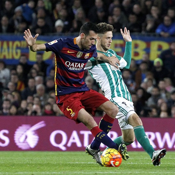 epa05084022 FC Barcelona&#039;s midfielder Sergio Busquets (L) vies for the ball with Real Betis&#039; Dutch striker Rick van Wolfswinkel (R) during the Spanish Liga Primera Division soccer match betw ...