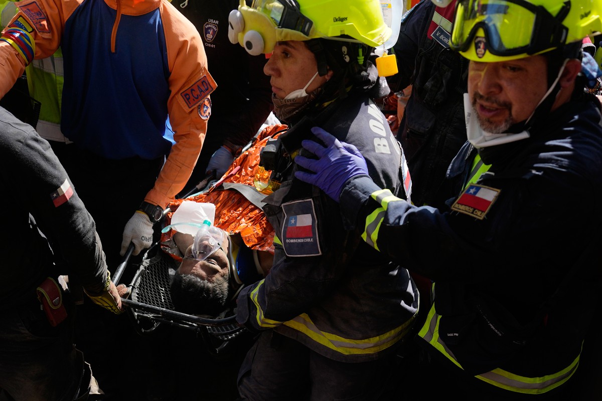 Chilean rescue workers carry Hernán Alberto Gil Flores after he was pulled from the rubble eight days after he was trapped by twin earthquakes that struck Catia La Mar, Venezuela, Thursday, July 2, 20 ...