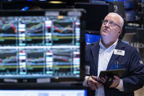 epa10976438 A trader works on the New York stock exchange floor as markets react to financial news pointing to less inflation in the economy and the temporary deal averting a US government shutdown...