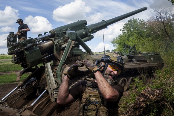 A Ukrainian soldier aka Mechanic, of 43rd artillery brigade, shows heart while firing by 2s7 self-propelled howitzer towards Russian positions at the frontline in Donetsk region, Ukraine, Monday, June ...