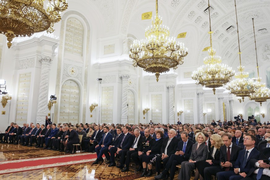 Participants listen to Russian President Vladimir Putin during celebrations marking the incorporation of regions of Ukraine to join Russia in the Kremlin in Moscow, Russia, Friday, Sept. 30, 2022. The ...