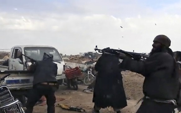 This frame grab from video posted online Monday, March 18, 2019, by the Aamaq News Agency, a media arm of the Islamic State group, shows Islamic State fighters firing their weapons during clashes with ...