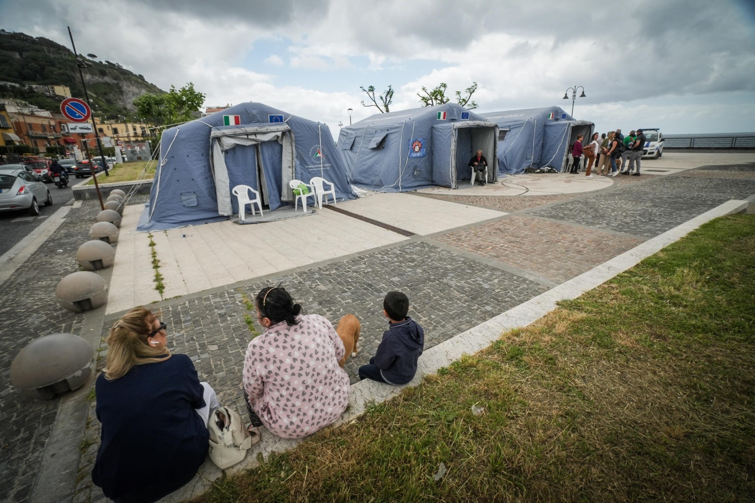 epa11357629 People walk in a tent city, in Naples, Italy, 21 may 2024. Hundreds of citizens of Pozzuoli, Naples were evacuated and spent the night in the two small tent cities set up by the Civil Prot ...