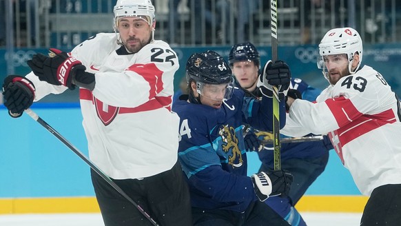 Finland's Mikael Granlund (64) is challenged by Switzerland's Nino Niederreiter (22) and Switzerland's Andrea Glauser (43) during a men's ice hockey quarterfinal game between Finla ...