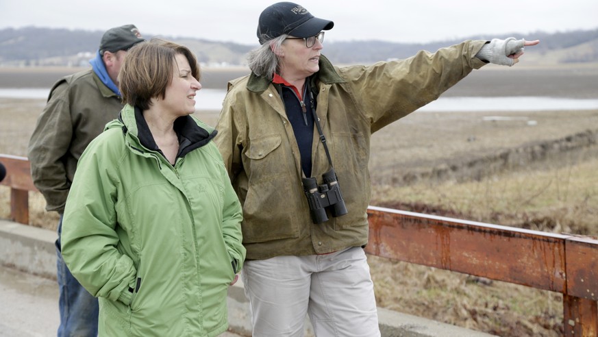 Pacific Junction, Iowa, resident Fran Karr, right, points out to Democratic presidential candidate Sen. Amy Klobuchar, D-Minn., the location of her flooded home, during a stop to the recently flooded  ...