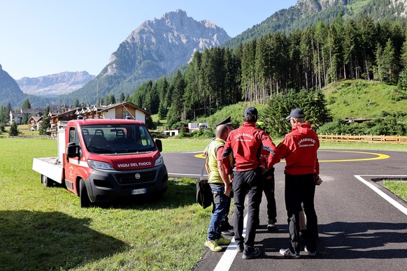 epa10051093 Rescue team gather at the bottom of the Marmolada Mountain in the aftermath of an avalanche, in Canazei, Italy, 04 July 2022. At least six people were killed and dozens were still missing  ...