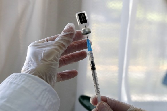 A nurse prepares a dose of the Pfizer-BioNTech vaccine against the COVID-19 at a health center in Athens, Wednesday, Jan. 20, 2021. Greece launched its COVID-19 vaccination program in late December wi ...