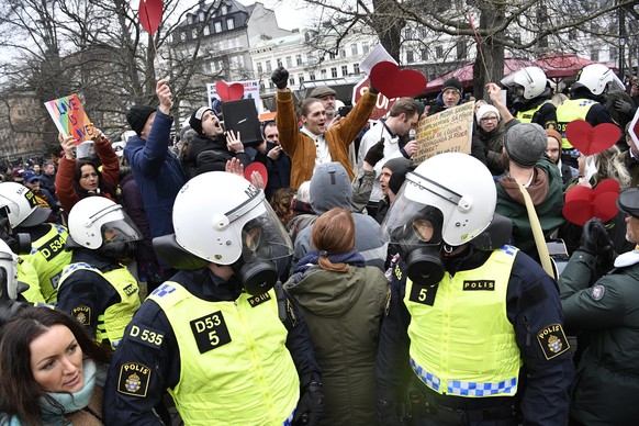 epa09085491 Riot police and protesters seen during a demonstration to oppose government restrictions to curb the spread of COVID-19, in Malmoe, Sweden, 20 March 2021. Demonstrations are planned across ...