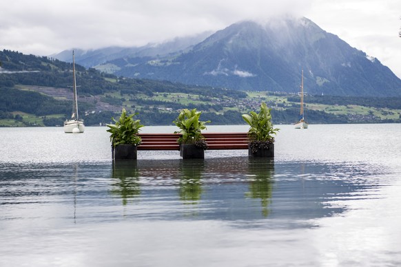 Eine Sitzbank steht im Wasser des Thunersees, am Donnerstag, 14. Juli 2021, in Neuhaus bei Interlaken. Nach den intensiven Regenfaellen der letzten Tagen werden die Ufer zum Teil ueberschwemmt. (KEYST ...