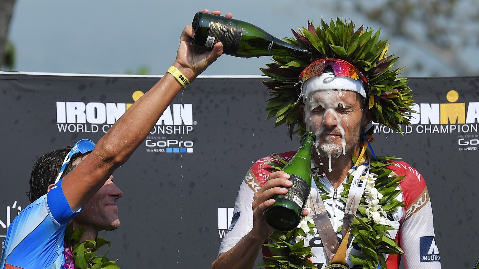 Winner Jan Frodeno, right, of Germany, gets champagne poured over him by Andreas Raelert, of Germany, who took second in the men&#039;s portion of the Ironman World Championship triathlon, Saturday, O ...