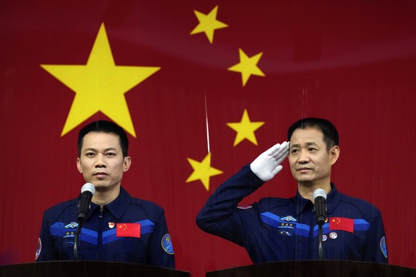 Chinese astronauts Nie Haisheng, right, salutes as he and fellow astronaut Tang Hongbo attend a press conference at the Jiuquan Satellite Launch Center ahead of the Shenzhou-12 launch from Jiuquan in  ...