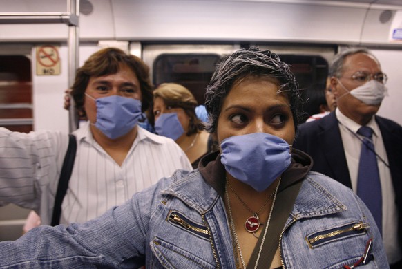 People wear surgical masks as a precaution against infection inside a subway in Mexico City, Friday, April 24, 2009. Mexican authorities said 60 people may have died from a swine flu virus in Mexico,  ...