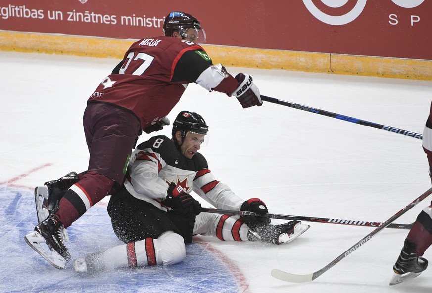 Latvia&#039;s Gints Meija, left, and Canada&#039;s Wojtek Wolski fight for the puck during an exhibition hockey game in Riga, Latvia, Sunday, Feb. 4, 2018. (AP Photo/Roman Koksarov)